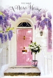 The photograph shows a tranquil, pastel-washed entryway that could easily be found along a leafy side street in South Tottenham, moments from Chestnuts Park, dressed up to celebrate a new home. A soft pink front door occupies the centre, its colour calm and inviting, with subtle brushstrokes visible in the paint that suggest recent care and attention. The door is set into whitewashed walls that hold a faint patina of age, their lightly worn texture giving the scene warmth and authenticity. On one side, a matching shutter, painted in slightly paler pink, rests against the wall as though waiting to be opened on a bright spring morning. Above the door, luxuriant wisteria spills down in generous cascades. The blossoms, a mix of lavender and soft lilac, hang in layered clusters that partially veil the top of the doorway, catching the light and casting delicate shadows across the wood below. Their airy, cascading form contrasts beautifully with the solid structure of the house, hinting at movement even in stillness. On the doorstep, positioned as if just delivered, stands a cylindrical florist's bucket in matte grey metal. It overflows with full-headed white and cream roses, their petals tightly packed at the centre and more relaxed at the edges, creating a plush, almost cloud-like effect. Sprays of gentle green foliage weave between the blooms, breaking up the ivory tones and adding a hint of garden freshness. Around the base of the bucket is a soft pink satin ribbon tied carefully in a bow, its trailing ends resting lightly against the step. The colour of the ribbon echoes the door and the wisteria, knitting the composition together in a soothing palette of blush, cream, and green. The overall atmosphere is quietly joyful and full of possibility, like the pause before stepping over the threshold for the first time, when the air feels scented with hope as much as flowers.